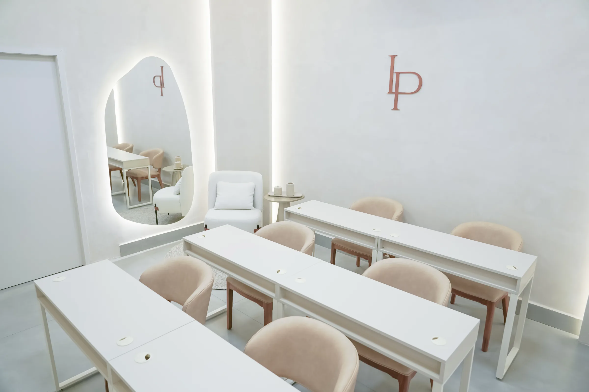 Sala de manicura da LePolli em Itu com mesas brancas, poltronas nude e logotipo LP