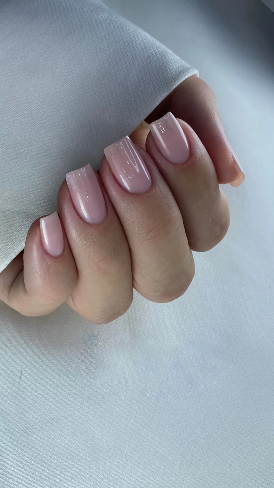 Unhas naturais quadradas com esmaltação nude e acabamento glossy